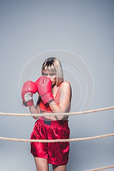 portrait of beautiful woman in sportswear and boxing gloves posing