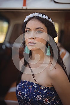 Portrait of beautiful woman standing by van