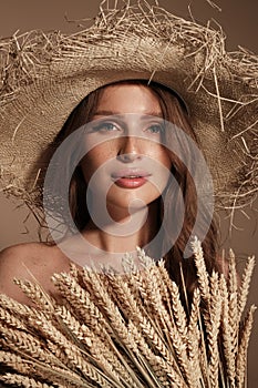 Portrait of a beautiful woman in a straw hat, loose hair and nude makeup. Beauty face