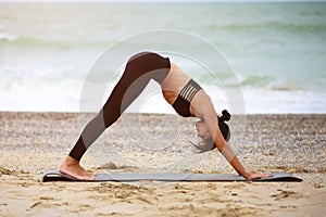 A portrait of beautiful woman stretching her arms and legs on the beach.