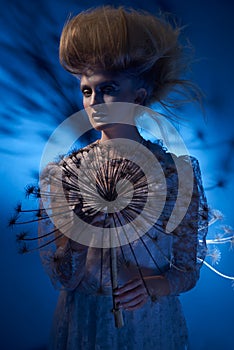 Portrait of a beautiful woman with stylish hairdo posing with big dandelion