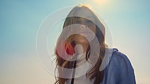 Portrait of beautiful woman in sunlight. Blue-eyed girl face in sunbeams outdoor