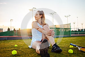 Portrait of a beautiful woman at sunset. Tennis court, athletic body. Fitness, weight loss, athlete smiles, happy