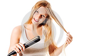Portrait of beautiful woman using hair straighteners.