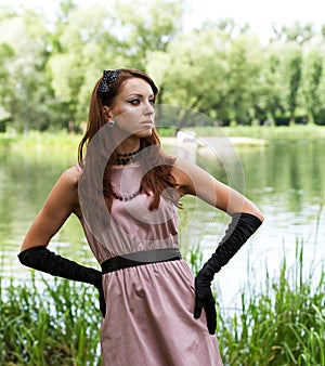 Portrait of a beautiful woman wearing vinatge outfit in summer park