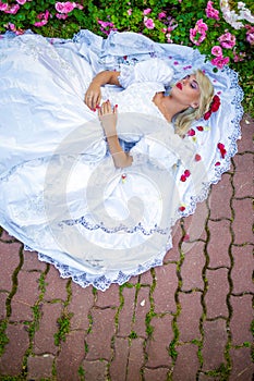 Portrait of beautiful woman in white dress lying