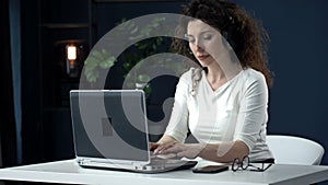 Portrait of a beautiful woman working with concentration at the laptop. Woman is satisfied with the result of her work.