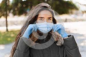 Portrait of beautiful women in medical mask and gloves. Self isolation in quarantine period of epidemy of coronavirus