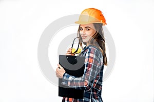 Portrait of beautiful worker model with hard hat and yellow glasses touching her lips isolated on white background