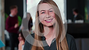 Portrait of beautiful young 30s successful blonde business woman cheerfully smiling at camera at trendy light coworking.