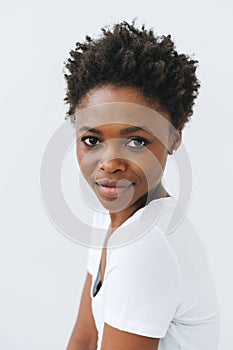 Portrait of beautiful young African American woman in white t-shirt isolated on white background