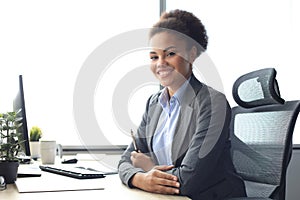 Portrait of beautiful young african american woman working on computer while sitting at the table