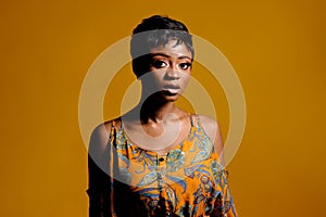 Portrait of a beautiful young African woman over yellow background. Studio picture