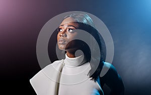 Portrait of a beautiful young African woman in white dress over black background