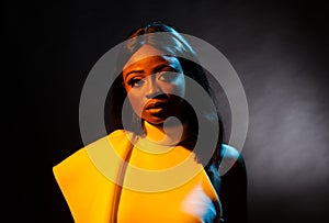 Portrait of a beautiful young African woman in white dress over black background