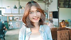 Portrait of Beautiful young asian brunette woman smiling while standing in cafe. Women lifestyle concept.