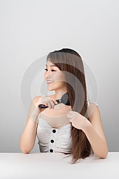 Portrait of a Beautiful Young Asian Female - combing her long straight hair