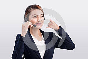 Portrait of beautiful young asian female customer service representative in headset looking at camera and smiling while isolated