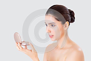 Portrait of beautiful young asian woman applying powder puff at cheek makeup of cosmetic.