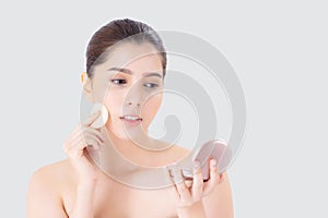 Portrait of beautiful young asian woman applying powder puff at cheek makeup of cosmetic.