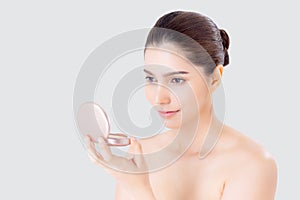 Portrait of beautiful young asian woman applying powder puff at cheek makeup of cosmetic.