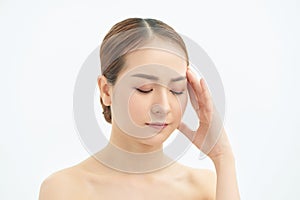 Portrait of beautiful young Asian woman with bare shoulders touching her temples feeling stress, on white background