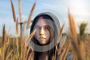 Portrait of beautiful young Asian woman enjoying nature on grass meadow at sunrise