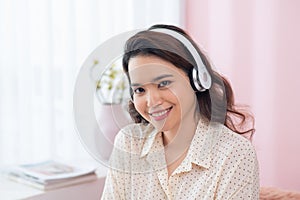 Portrait of beautiful young Asian woman listening to music