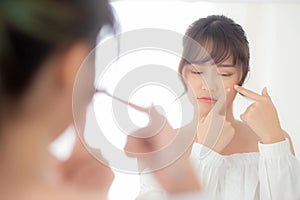 Portrait beautiful young asian woman looking the mirror is a acne, zit treatment, girl problem beauty face photo