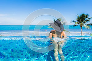 Portrait beautiful young asian woman relax in luxury outdoor swimming pool in hotel resort nearly beach sea ocean