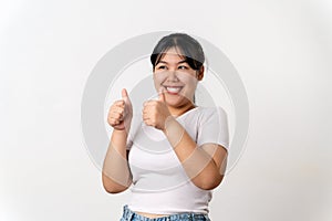 The portrait of beautiful young Asian woman showing thumb up hand sign on white background. Agreement, approval, recommending,