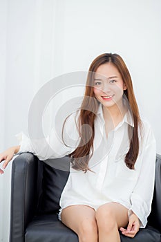 Portrait of beautiful young asian woman smile and happy sitting on chair in the living room