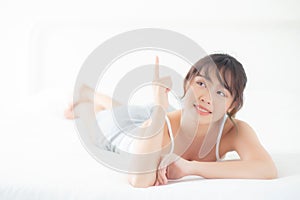 Portrait beautiful young asian woman smile wake up healthy and wellness at morning, beauty asia girl lying and pointing something