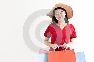 Portrait of beautiful young asian woman wearing red long dress  holding shopping bags isolated over white background.
