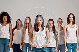 Portrait of beautiful young asian woman in white shirt looking at camera. Group of diverse women posing, standing