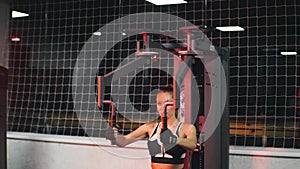 Portrait of a beautiful young athletic woman training in the gym with red neon light