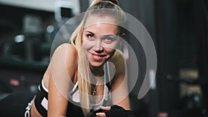 Portrait of a beautiful young athletic woman training in the gym with red neon light