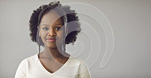 Portrait of beautiful young black woman with Afro hairstyle on gray copy space banner