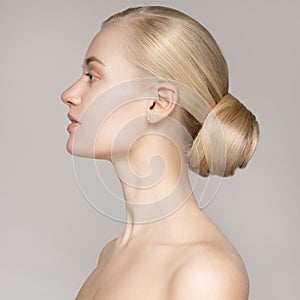 Portrait Of A Beautiful Young Blond Woman With Bun Hairstyle.