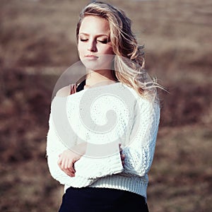 Portrait of a beautiful young blonde girl in the white pullovers photo