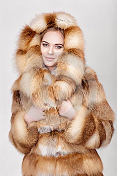 Portrait of beautiful young blonde woman in luxury Fox fur coat.