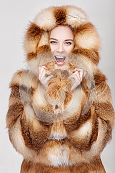 Portrait of beautiful young blonde woman in luxury Fox fur coat.