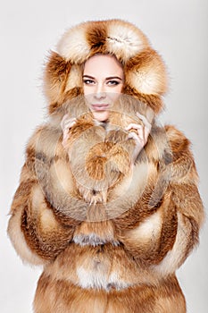 Portrait of beautiful young blonde woman in luxury Fox fur coat.