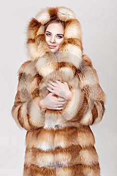 Portrait of beautiful young blonde woman in luxury Fox fur coat.