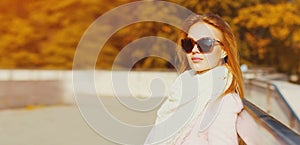 Portrait of beautiful young blonde woman wearing sunglasses in autumn park