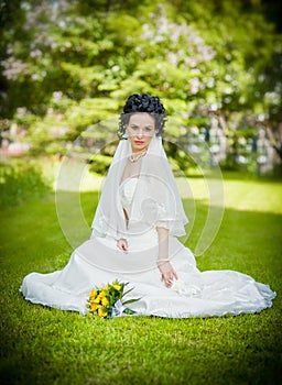 Portrait of beautiful young bride in garden