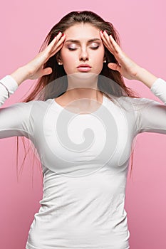 Portrait of beautiful young brunette with bare shoulders touching her temples feeling stress