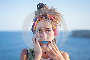 Portrait of a beautiful young brunette girl with African tribal makeup or face paint