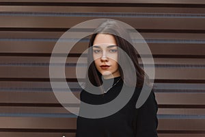 Portrait of a beautiful young brunette woman with natural make-up with beautiful brown eyes in a black stylish sweater