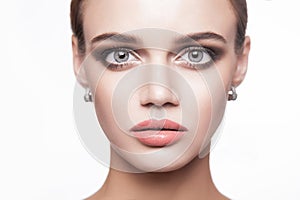 Portrait of beautiful young brunette woman with smoky eyes makeup and natural lips looking at camera